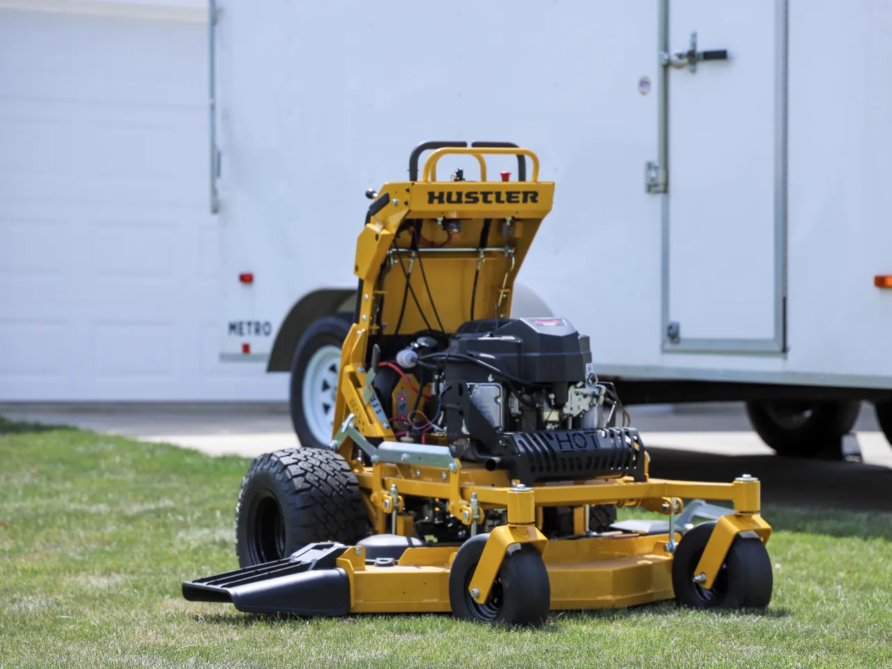 Landon's Lawn Care operator and equipment trailer at a commercial property